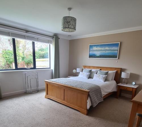 a bedroom with a bed and a large window at Tree Top View Sheringham - Reverse Living - EV Charger - Quirky in Sheringham