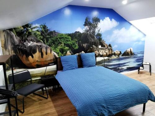 ein Schlafzimmer mit einer blauen Wand mit einem Dinosaurier-Wandbild in der Unterkunft Le temps d'une pause 