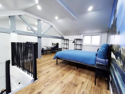 ein Schlafzimmer mit einem blauen Bett in einem Zimmer in der Unterkunft Le temps d'une pause 