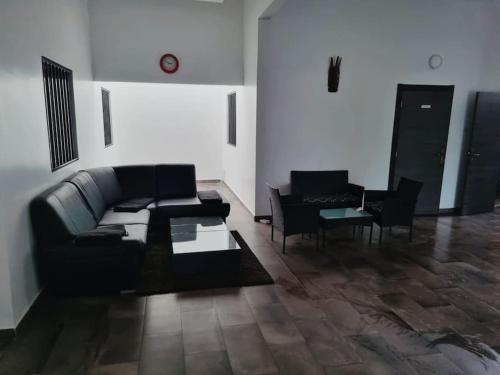 a living room with a black couch and chairs at Villa Massai avec piscine au cœur de Saly in Sali Nianiaral