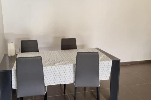 a table with four chairs sitting around it at Villa Massai avec piscine au cœur de Saly in Sali Nianiaral