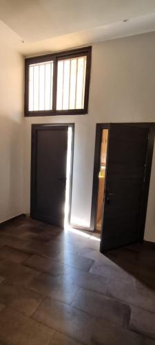 an empty room with a door and a window at Villa Massai avec piscine au cœur de Saly in Sali Nianiaral
