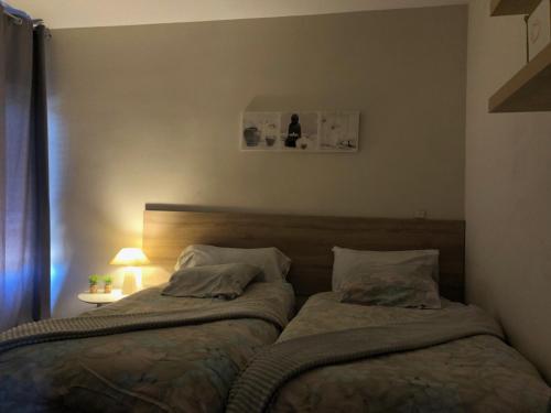 a bedroom with two beds and a table with a lamp at Urbanización las Gondolas, Espectaculares Vistas in Almuñécar