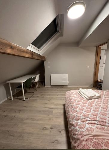 a bedroom with a bed and a desk in it at 2 bedroom and kitchen in Mons