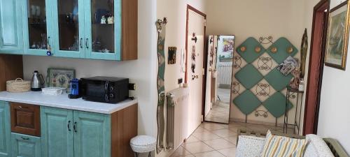 eine Küche mit blauen Schränken und eine Tür, die zu einem Flur führt in der Unterkunft Casa Anna B&B in Castellammare di Stabia