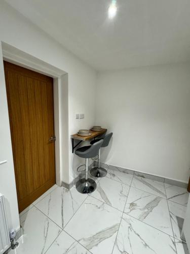 Zimmer mit einem Schreibtisch, einem Stuhl und einer Tür in der Unterkunft Luxary private detached property in Brettell Lane