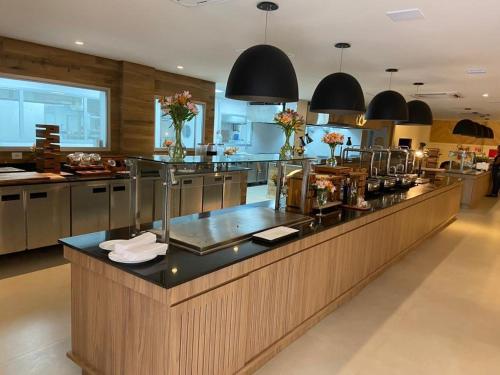 a large kitchen with a large counter with flowers on it at Apartamento completo no resort Water Park in São Pedro
