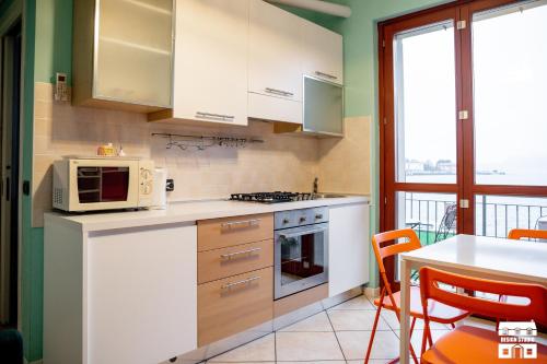 a kitchen with white appliances and a table with chairs at THE BEACH by Design Studio in Bellano