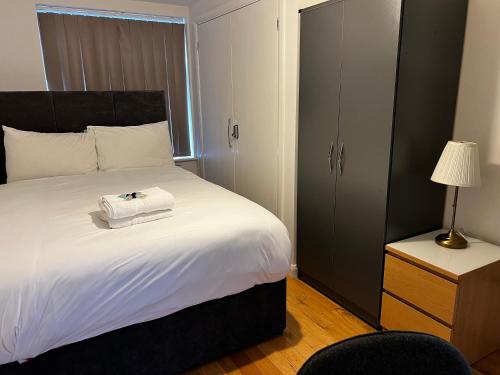 a bedroom with a large bed with a black headboard at Dartford Stay in Kent