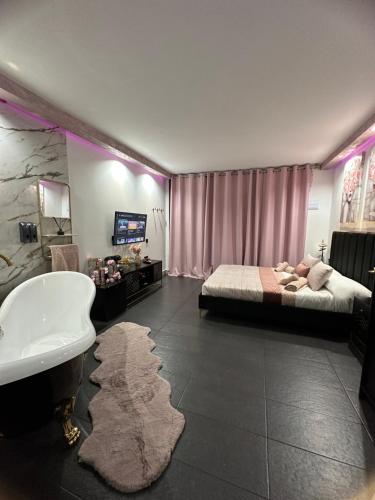 1 dormitorio con cama, bañera y lavamanos en Habitación LUXURY LOVE, en Sant Carles de la Ràpita