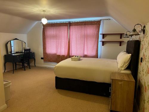 um quarto com uma cama grande e uma janela rosa em Dartford Stay em Kent