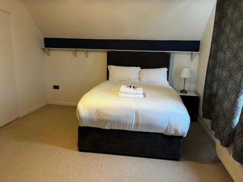 a bedroom with a bed with two towels on it at Dartford Stay in Kent