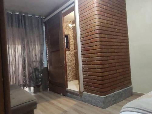 una parete di mattoni con una porta in una stanza di Hospedagem San Gonzales Two a Sorocaba