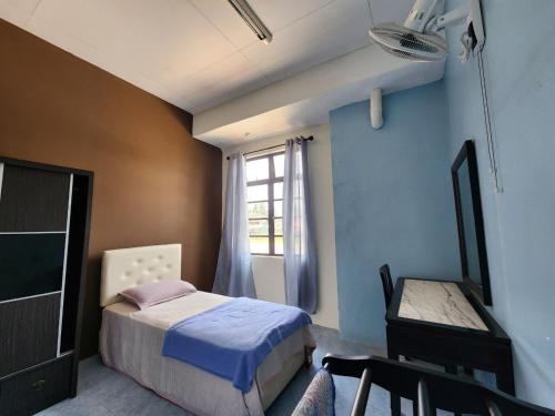 een slaapkamer met een bed, een tafel en een raam bij Deummah Guest Room in Cukai