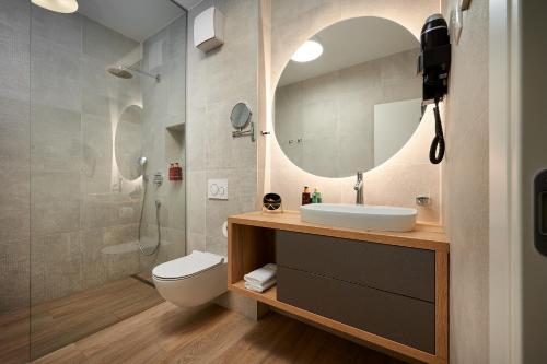 a bathroom with a sink and a toilet and a mirror at Villas Lucy - 1 Lemon -outdoor pool , 2 Cherry-indoor pool and 3 Plum-outdoor pool in Marina