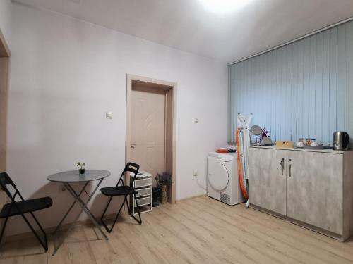 een keuken met een koelkast en een tafel en stoelen bij Rose Valley Guests room in Kazanlik