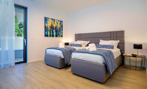 a bedroom with two beds and a painting on the wall at Villas Lucy - 1 Lemon -outdoor pool , 2 Cherry-indoor pool and 3 Plum-outdoor pool in Marina