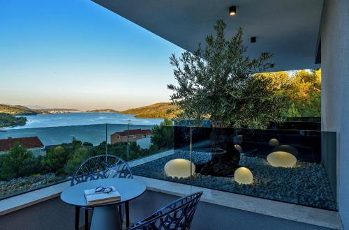a balcony with a table and chairs and a view of the ocean at Villas Lucy - 1 Lemon -outdoor pool , 2 Cherry-indoor pool and 3 Plum-outdoor pool in Marina