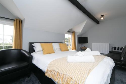 a bedroom with a bed and a black chair at Pass the Keys Modern en-suite room in country PubRestaurant 3 in Llanddona