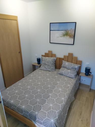 een slaapkamer met een bed en een foto aan de muur bij Appartement Mimizan Plage accès direct plage surveillée in Mimizan