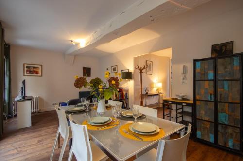 una sala da pranzo con tavolo e sedie bianchi di Terrasse sur la Tour Garçonnet a Amboise