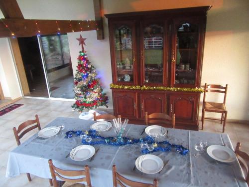 a dining room with a table with a christmas tree at Gîte du bois de la Minette in Benayes