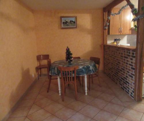 a dining room with a table and chairs with a christmas tree on it at Gîte du bois de la Minette in Benayes