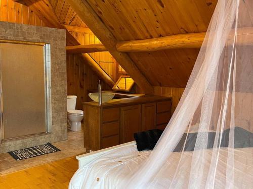 Schlafzimmer mit einem Bett mit Moskitonetz in der Unterkunft Casa Madera Chalet in Val des Monts