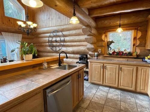 a kitchen in a log cabin with a sink at Casa Madera Chalet in Val des Monts