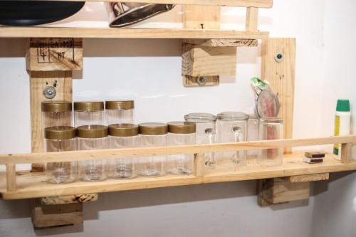 a wooden shelf with glass jars on it at Cinnamon Eco Villa 1 in Hikkaduwa