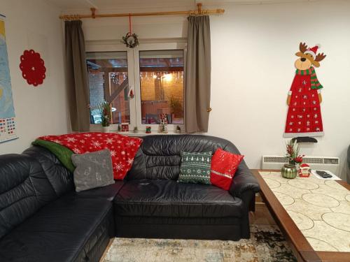 um sofá de couro preto numa sala de estar com uma árvore de Natal em Regina Ranch em Igal