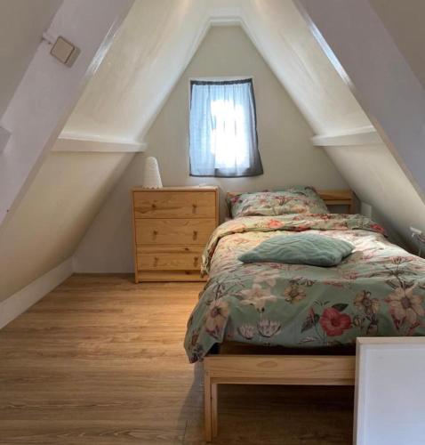 um quarto com uma cama, uma cómoda e uma janela em Dromen aan het strand em Egmond aan Zee
