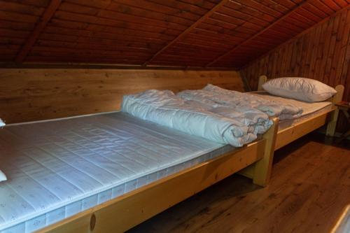 two beds in a room with wooden floors at Apartma Tisa in Zreče