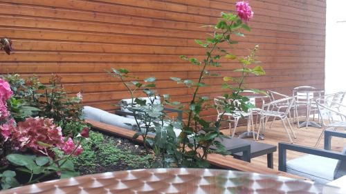 a garden with tables and chairs and a pink flower at Mercure Paris Bastille Marais in Paris