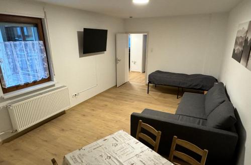 a living room with a couch and a window at 5-room apartment (120 sqm) with 2 bathrooms, 2 kitchens, bar area & balcony directly in the city centre in Karlsruhe