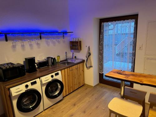 a kitchen with a washing machine and a sink at 5-room apartment (120 sqm) with 2 bathrooms, 2 kitchens, bar area & balcony directly in the city centre in Karlsruhe