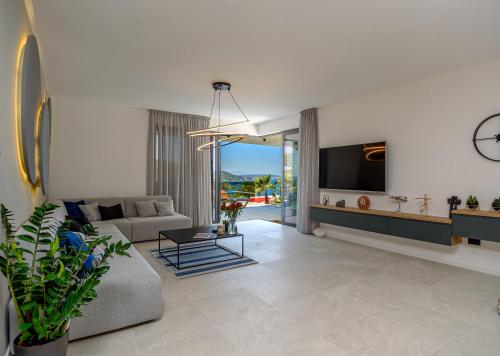 a living room with a couch and a tv at Villas Lucy - 1 Lemon -outdoor pool , 2 Cherry-indoor pool and 3 Plum-outdoor pool in Marina