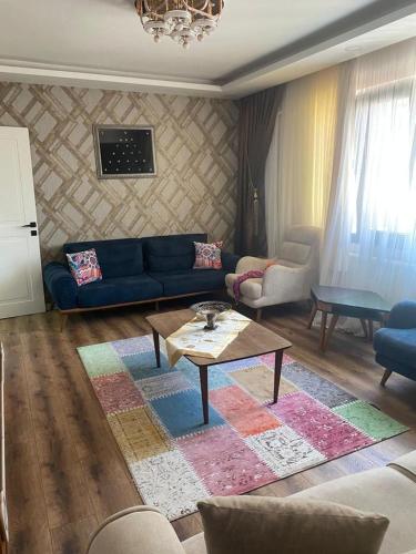 a living room with a blue couch and a table at Konuk evi in Karaköprü Köyü
