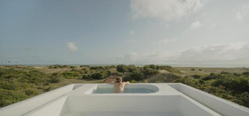 eine Person in einer Badewanne auf dem Dach eines Gebäudes in der Unterkunft Casa Attico - Design Beach House in Touros