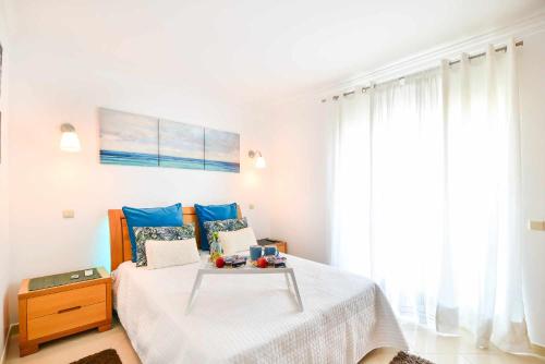 a bedroom with a bed with a table on it at Apartamento Moderno Albufeira L14 in Albufeira