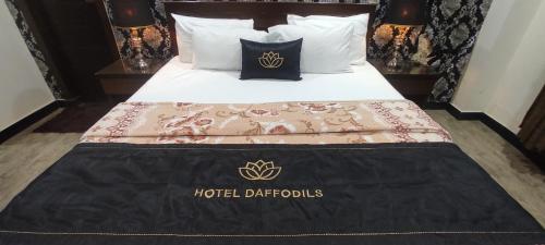 a bed with a hotel dothids blanket on it at Hotel Daffodils in Rawalpindi
