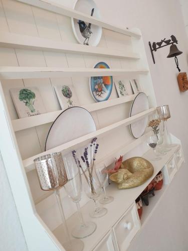 a white shelf with glasses and plates on it at Elbe Garden Paradise in Dresden