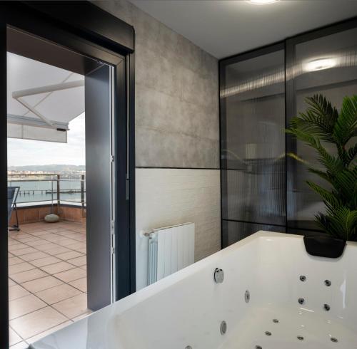 桑圖爾特西的住宿－Atico Lujo Costa Vasca Bilbaoterraza mar jacuzi，一间带浴缸和大镜子的浴室