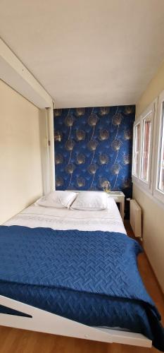 um quarto com uma cama grande e uma parede azul em Le Sleipnir - Appartement cantilien calme (proche gare SNCF) em Chantilly