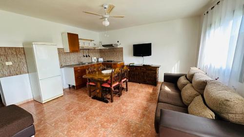 sala de estar con sofá, mesa y cocina en Apartamento La Dehesa, en Uga