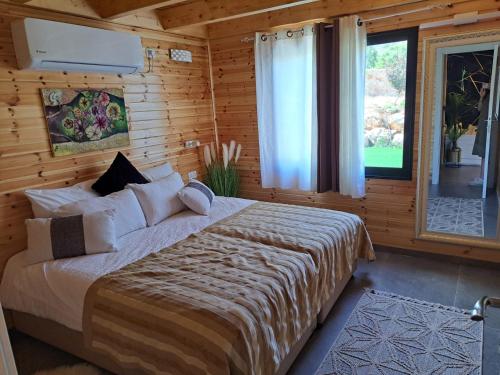 1 dormitorio con 1 cama en una habitación de madera en צימר בקתה מול הנוף, en Safed