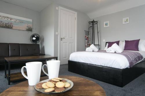 a bedroom with a bed and a table with a plate of cookies at Pass the Keys Modern en-suite room in country PubRestaurant 4 in Llanddona