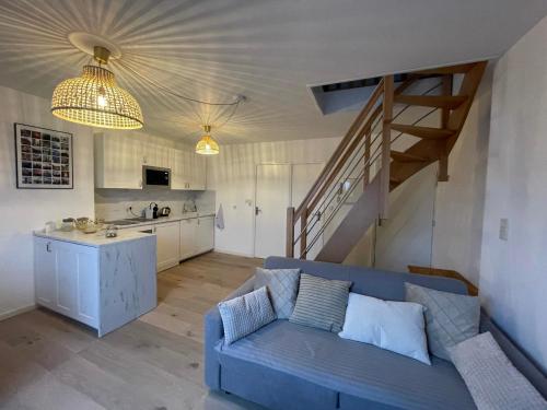 een woonkamer met een blauwe bank en een keuken bij Coup de cœur~Duplex cocoon vue sur le beffroi -Top Séjour Arras in Arras