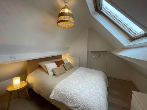 een slaapkamer met een wit bed en een raam bij Coup de cœur~Duplex cocoon vue sur le beffroi -Top Séjour Arras in Arras