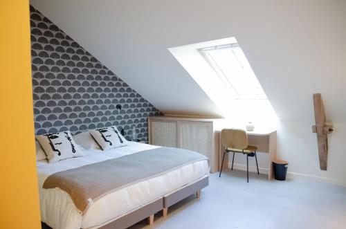 a bedroom with a large bed and a skylight at DOMAINE LE MEZO in Ploeren